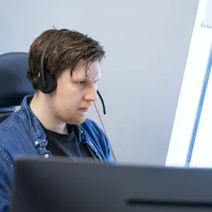 En ansatt i Hemit snakker i telefonen med en helsearbeider