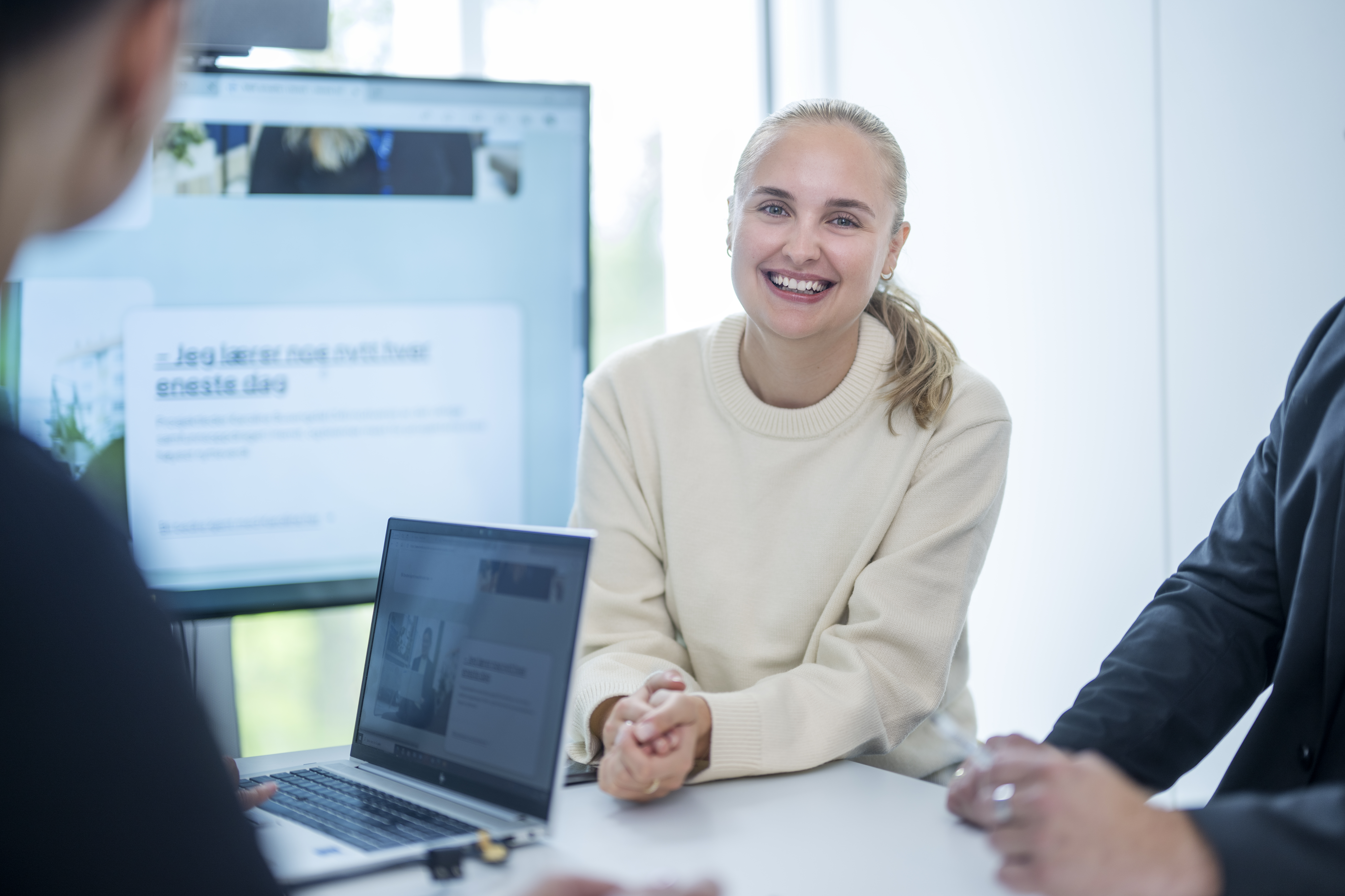 Kvinnelig ansatt som ser i kamera og smiler