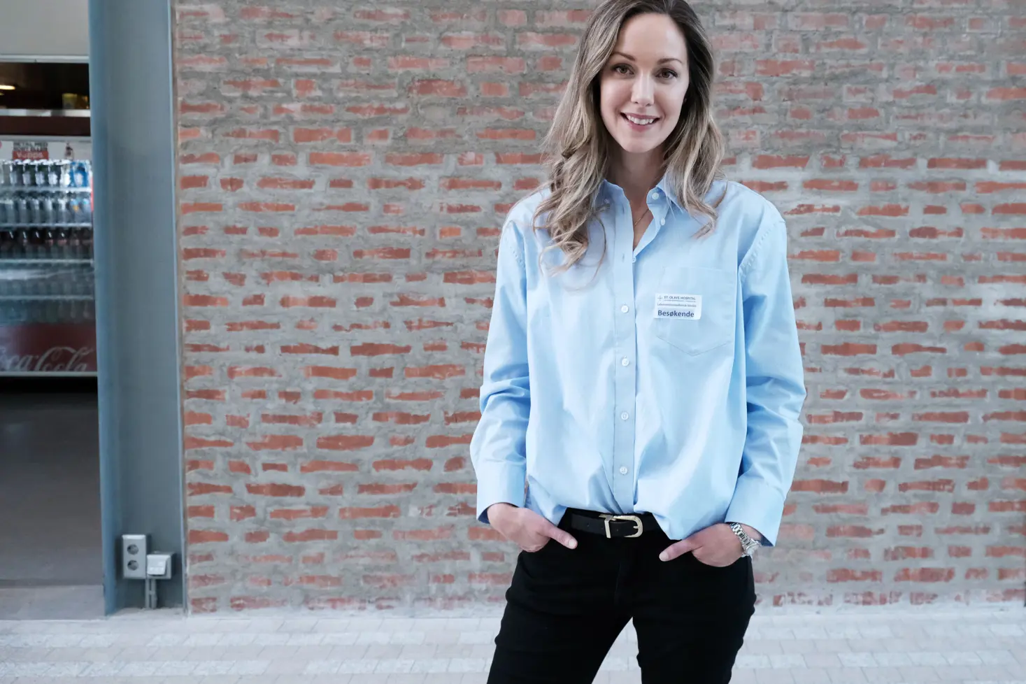 En person som står foran en murvegg