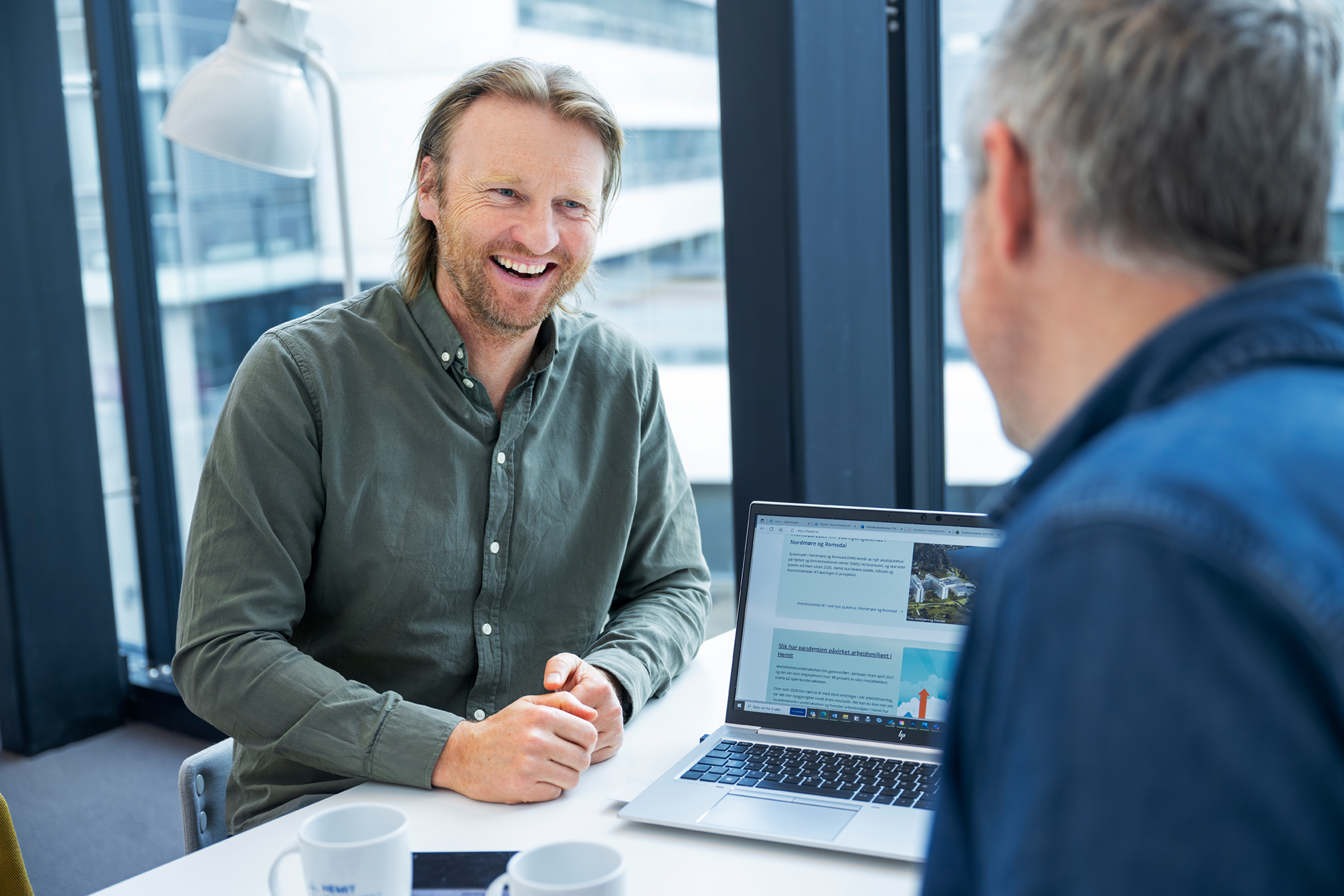 En mann som smiler til en annen mann