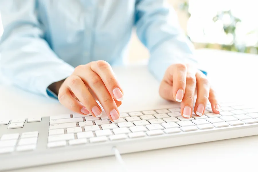 En ansatt sitter å skriver på et tastatur