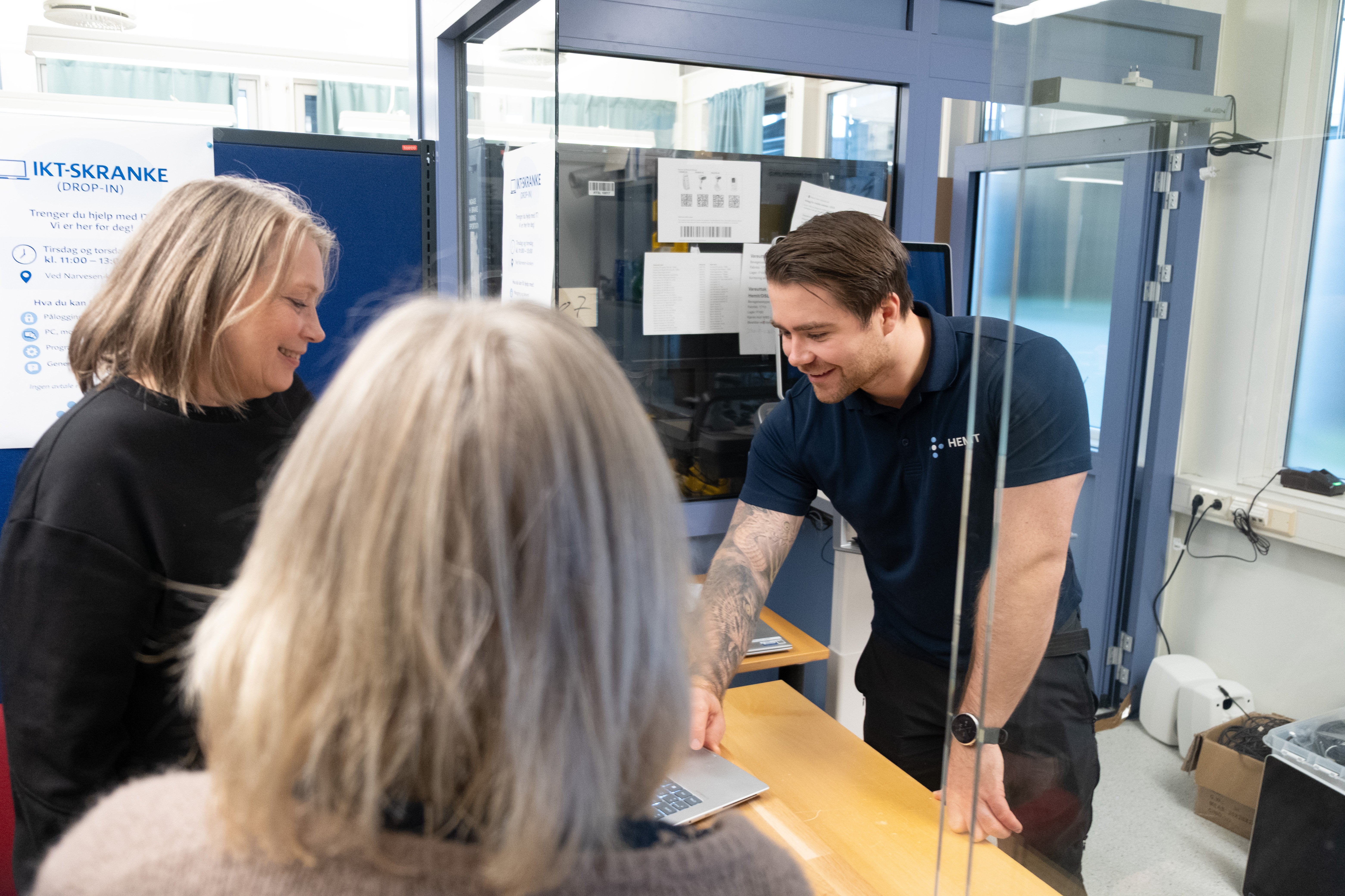 Mannlig ansatt i Hemit står i en servicekiosk og yter service på sykehuset Levanger