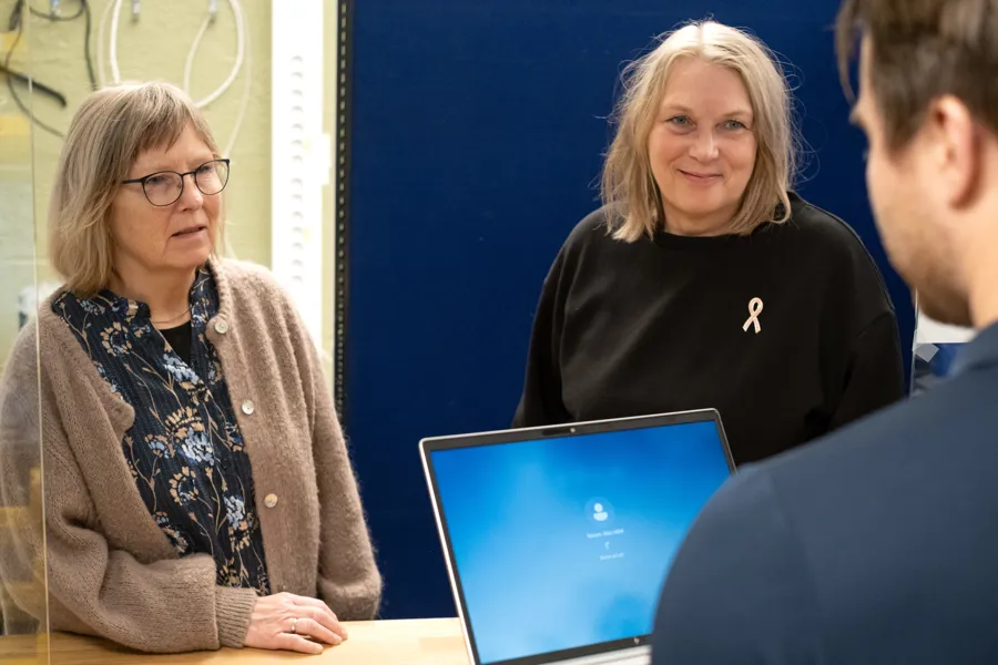 To damer får pc-hjelp.