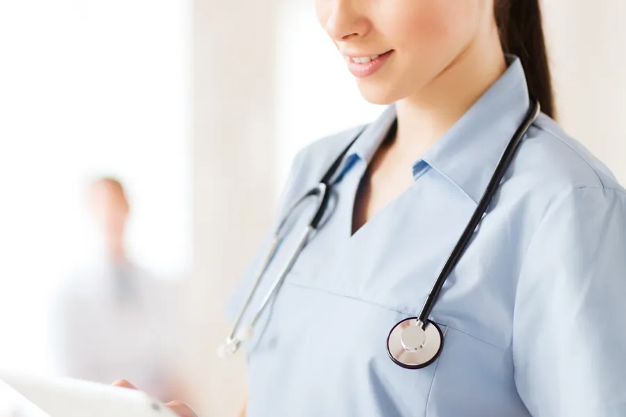 Helsepersonell leser tekst fra et nettbrett